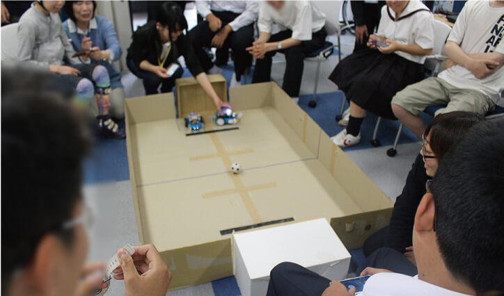 mbotというロボットを使ったサッカーゲームをしている風景